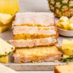 Square image of bread with slices cut on parchment paper.