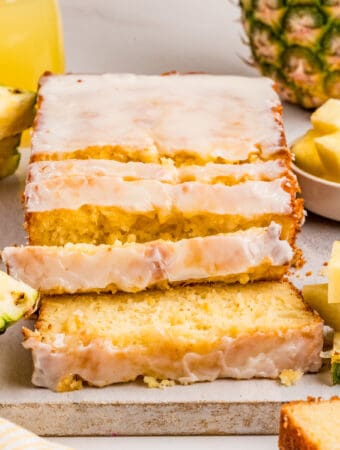 Square image of bread with slices cut on parchment paper.