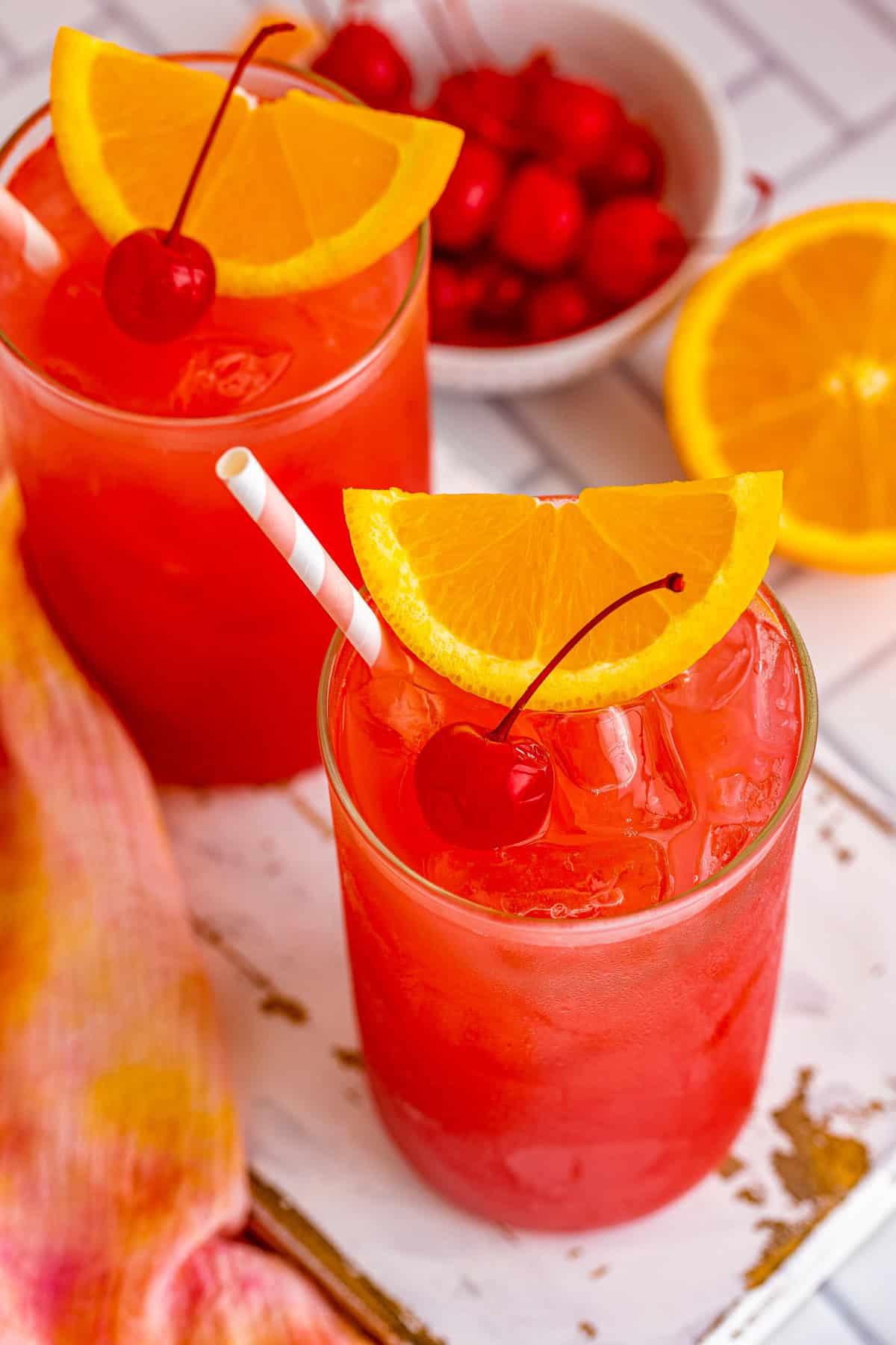 Overhead of finished Sex on the Beach Cocktail Recipe garnished with cherry and orange slice.