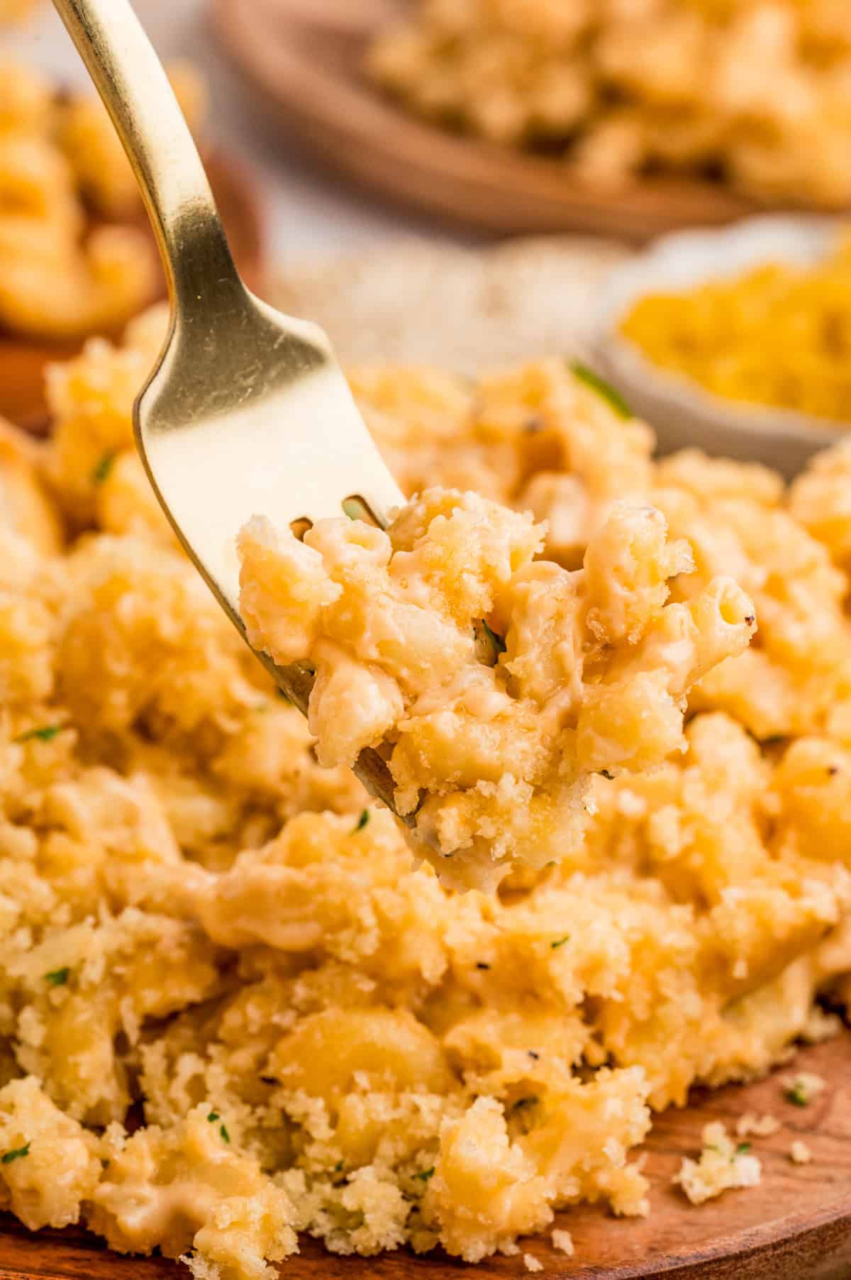 Fork holding up some of the mac and cheese from the plate.