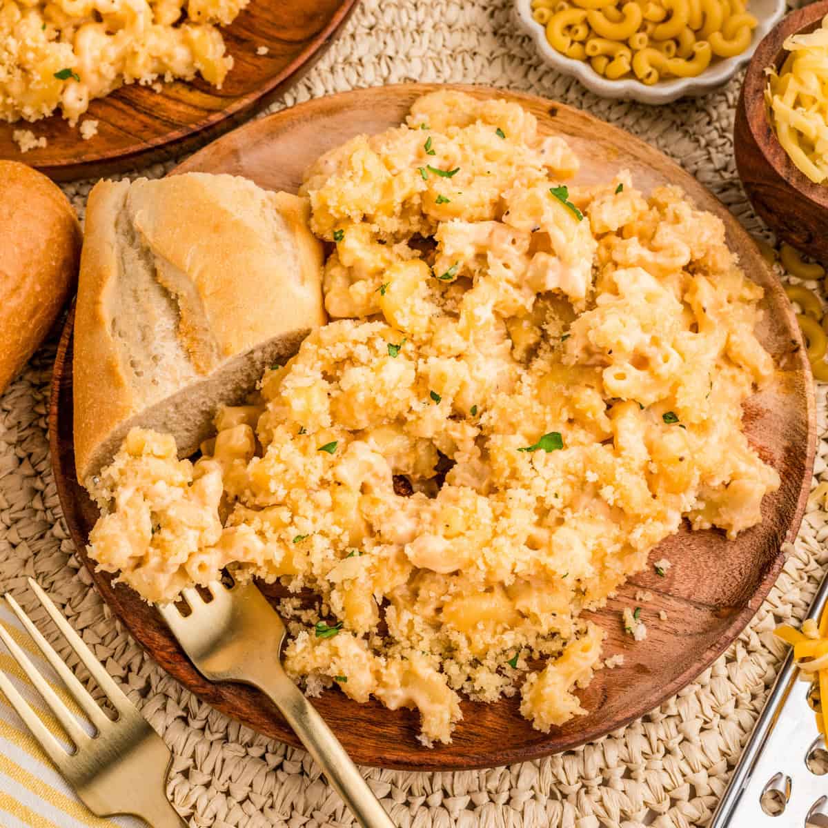 Close up square image of mac and cheese on plate with bread.