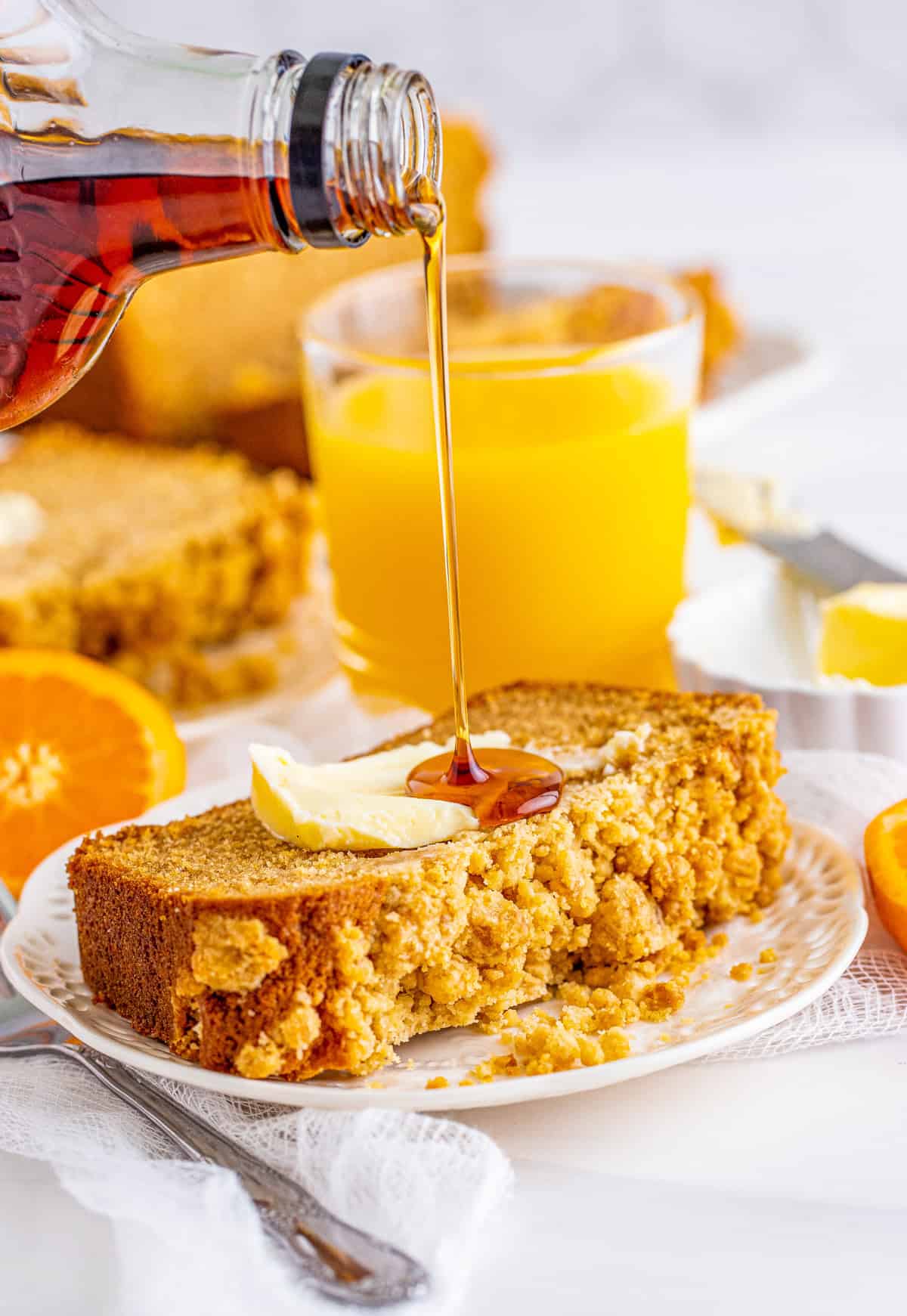Slice of bread on plate with butter and syrup being poured over it.