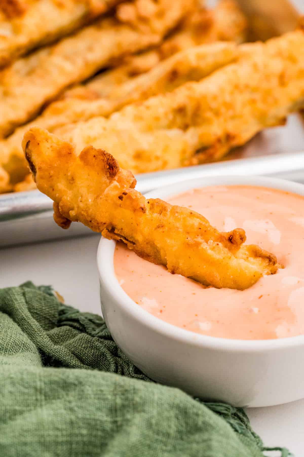 One pickle in dipping sauce.