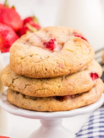 Square image of stacked cookies on white pedestal.