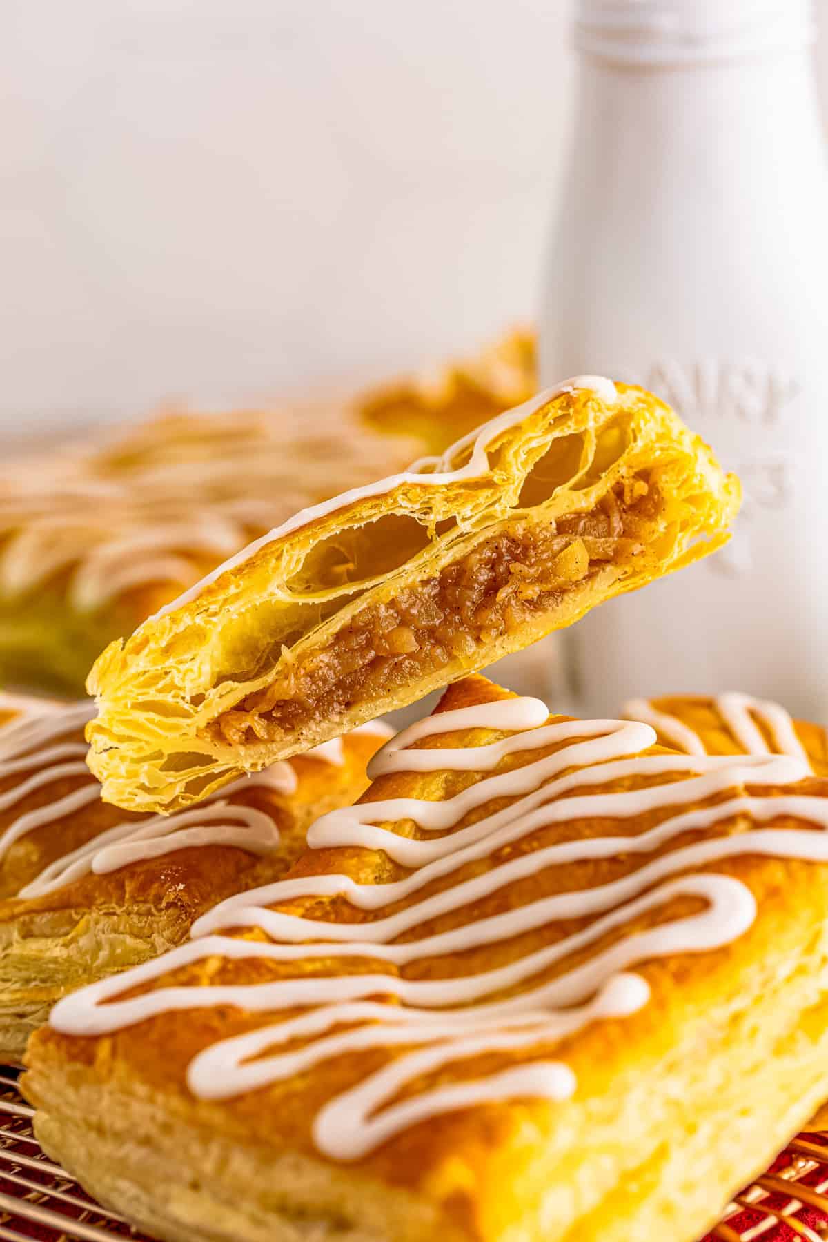 One strudel cut in half layered on top of a full strudel showing the inside filling.