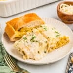 Square image of two rolls on plate with garlic bread.