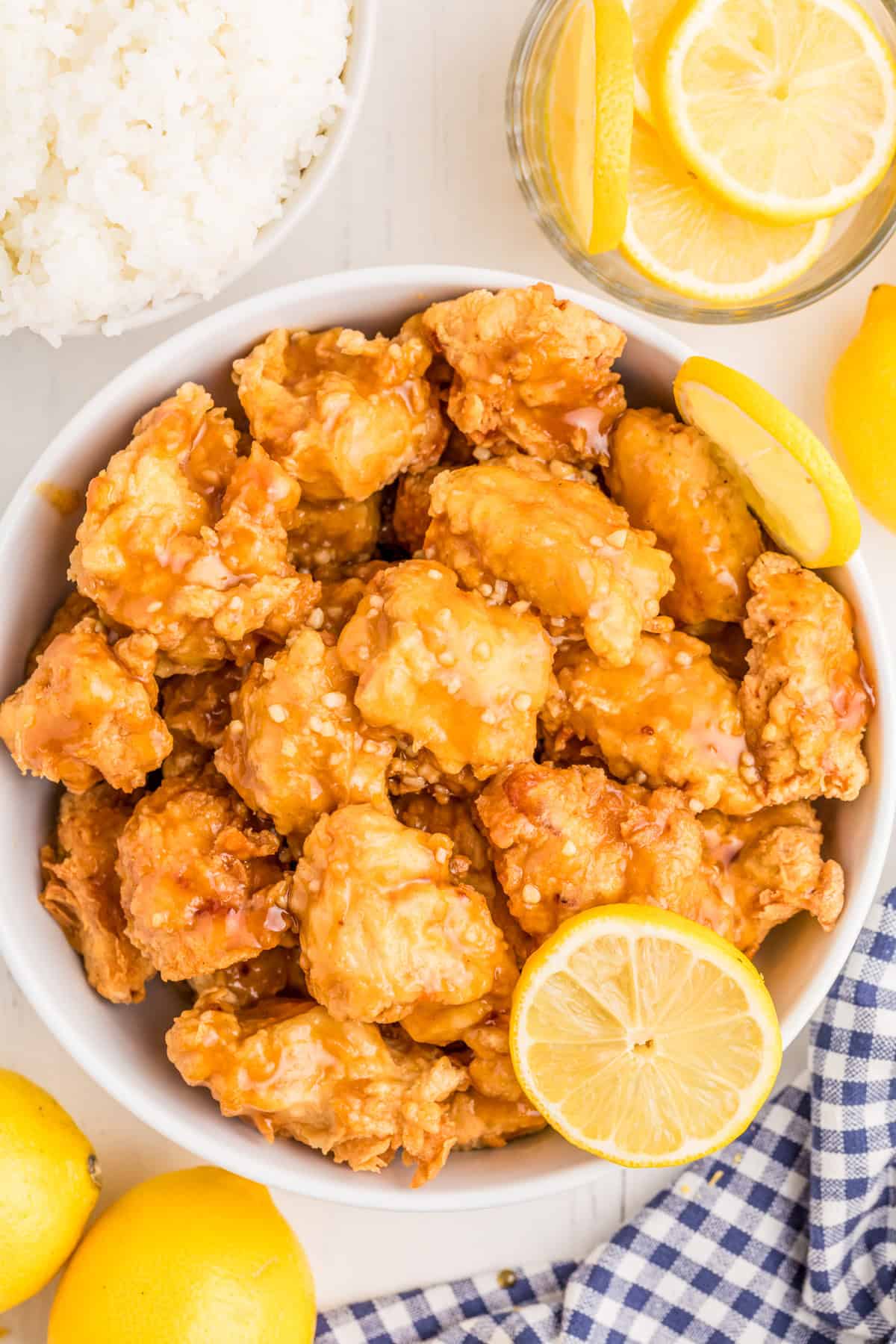 Overhead of chicken in bowl with lemon slices.