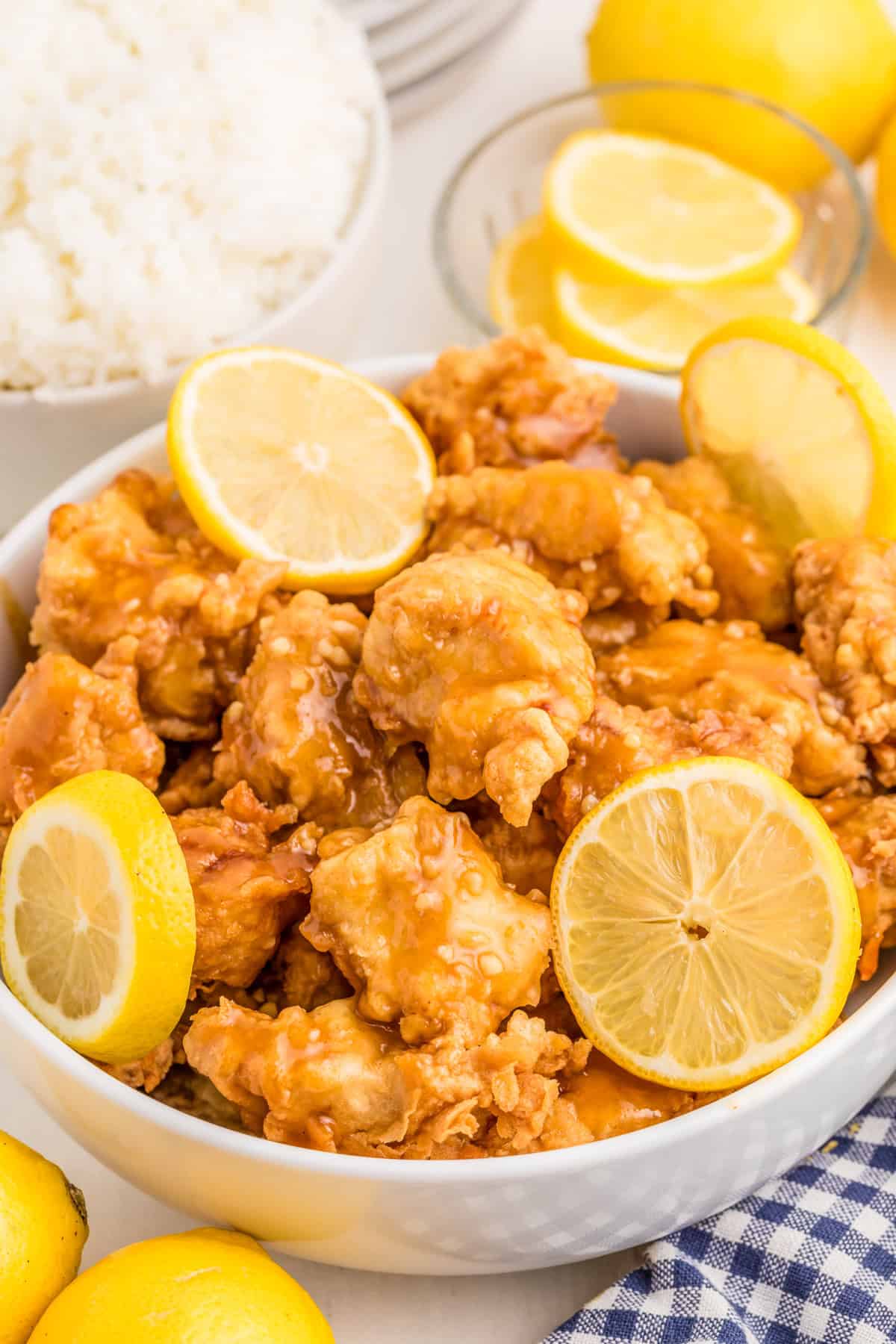 Finished Chinese Lemon Chicken in bowl with sauce and lemon slices.