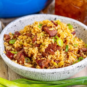 Close up of bowl of rice, showing the sausage and green onions.