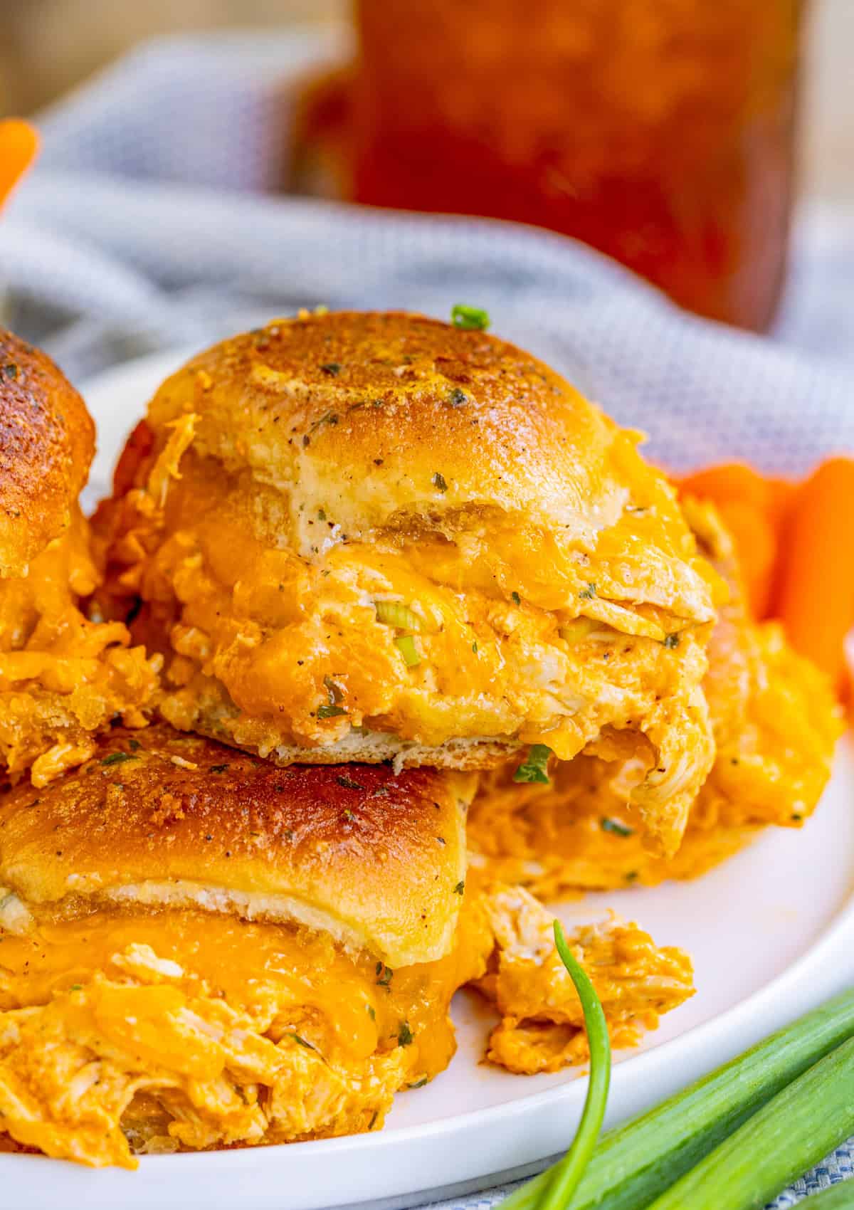 Buffalo Chicken Sliders on white plate stacked on top of one another.