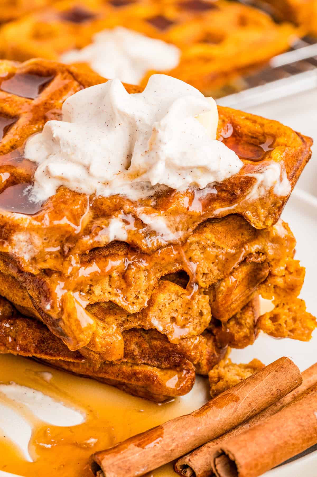 Stacked waffles on white plate showing some of the waffles cut out.