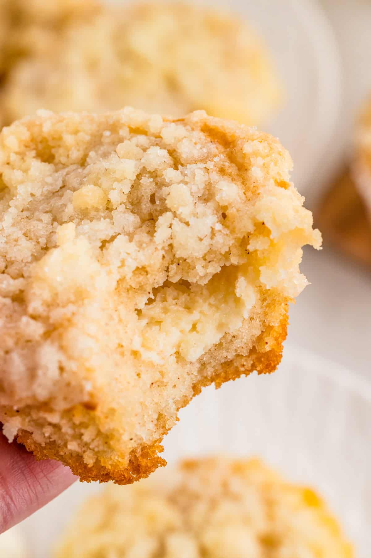 Close up of one muffin with bite taken out of it showing the inside filling.