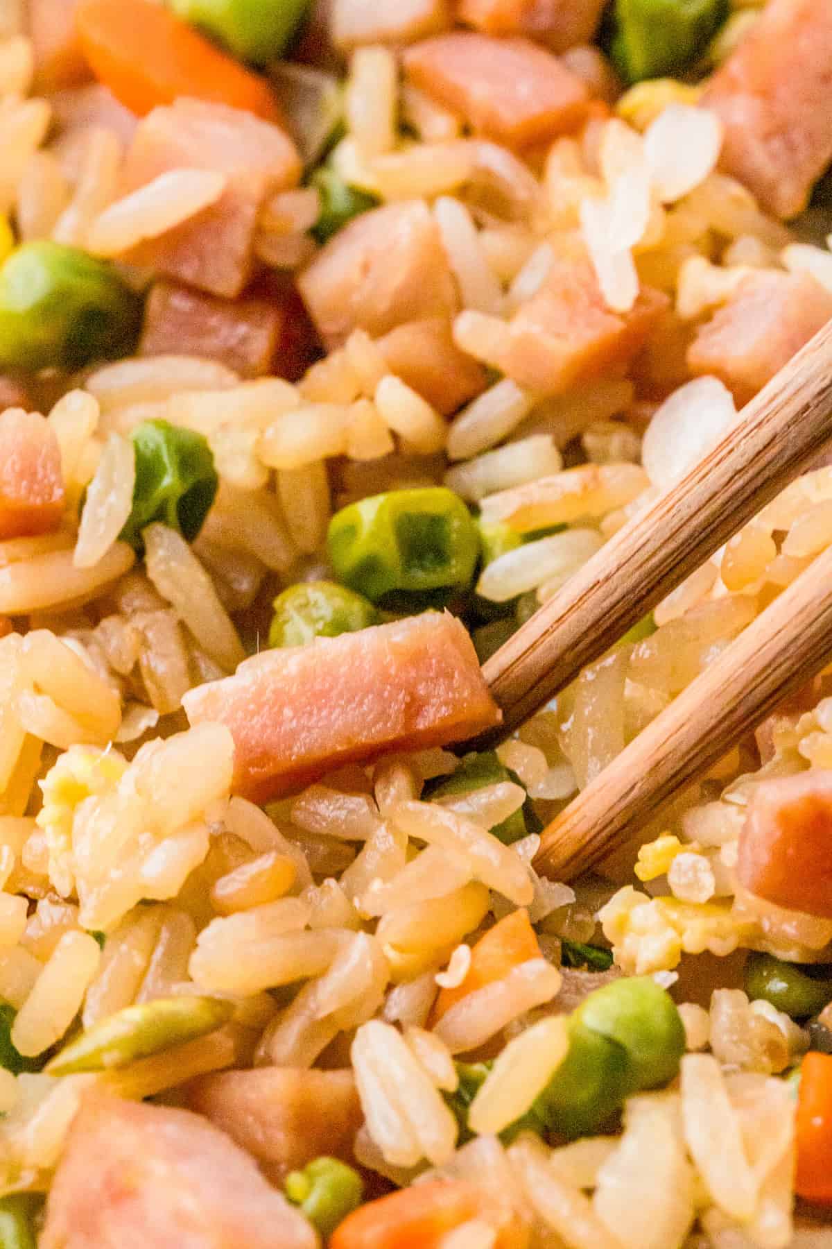 Close up of chopsticks going into a bowl of the rice.