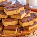 Square image of stacked bars on wooden platter with chocolate chips on platter.