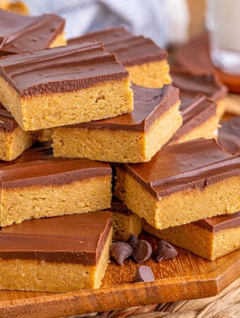 Square image of stacked bars on wooden platter with chocolate chips on platter.