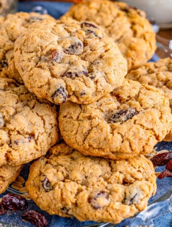 Close up square image of cookies stacked on blue linen.